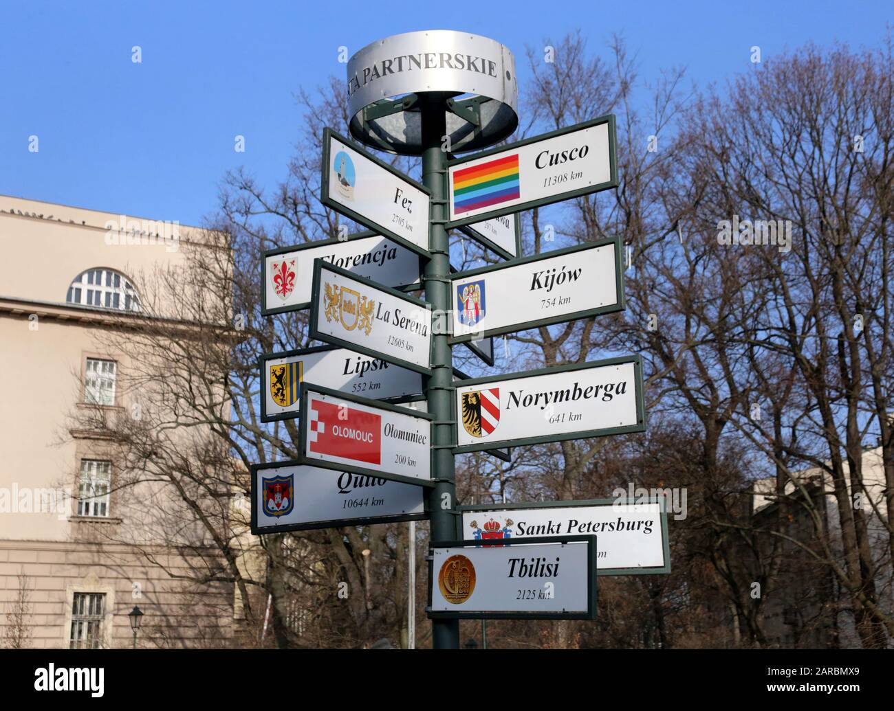 Cracow. Krakow. Poland. Signpost showin direction and distances to Cracow`s twin cities in the center of the Old Town in front of  Wawel castle. Stock Photo